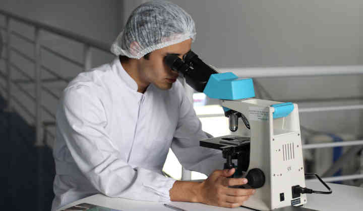 Scienctist using microscope